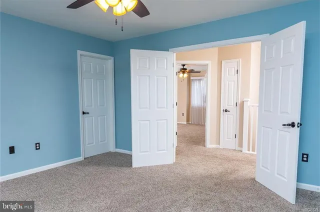 a view of a bedroom with a chandelier fan and closet area