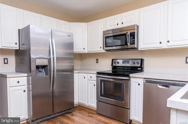a kitchen with stainless steel appliances and white cabinets