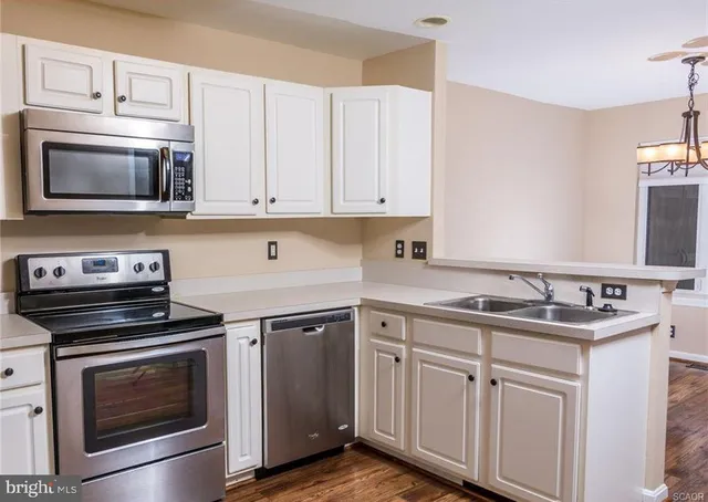 a kitchen with cabinets appliances and a sink