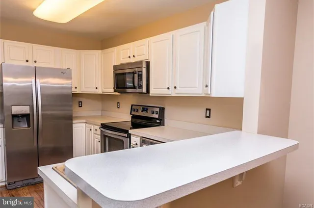 a kitchen with stainless steel appliances a refrigerator a stove a microwave and cabinets
