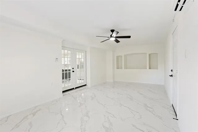 an empty room with fan and windows