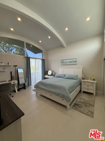 a bedroom with a bed and a large window