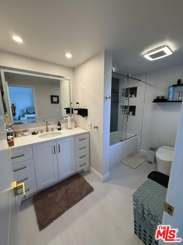 a spacious bathroom with a tub sink and mirror