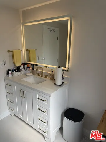 a bathroom with a granite countertop sink and a toilet