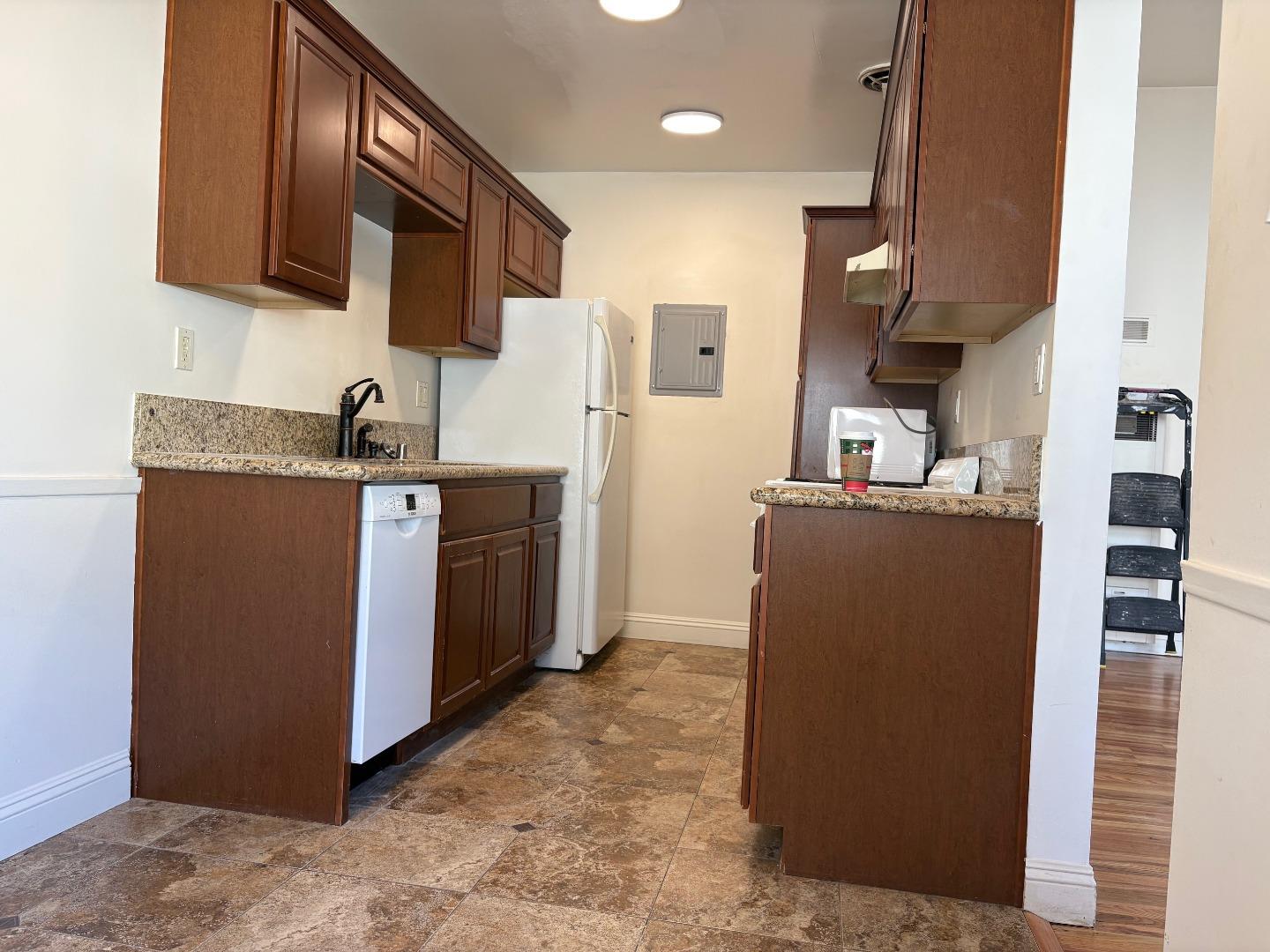 11719 Mayfield Avenue, Unit 6 Los Angeles, CA 90049 - Photo 11 of 20 a kitchen with stainless steel appliances granite countertop a refrigerator a stove a sink and a microwave