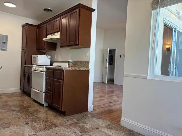 a kitchen with stainless steel appliances granite countertop a stove a refrigerator and a sink