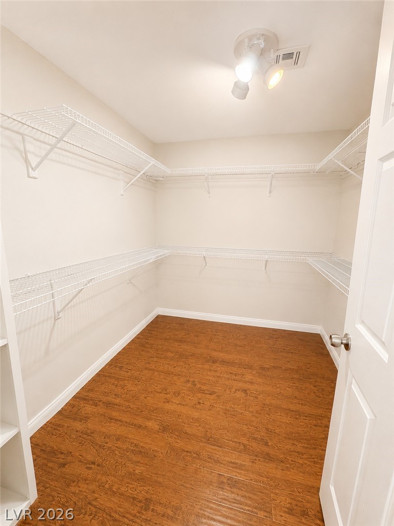 7213 London Bridge Avenue Las Vegas, NV 89130 - Photo 10 of 11 This spacious walk-in closet offers ample storage with durable wire shelving and warm wood flooring.