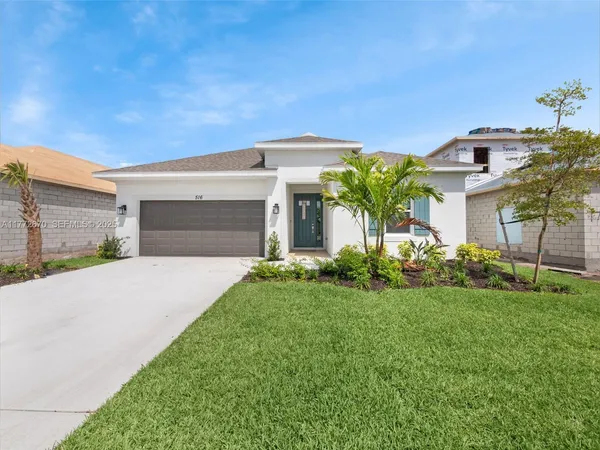 a front view of a house with a yard and garage