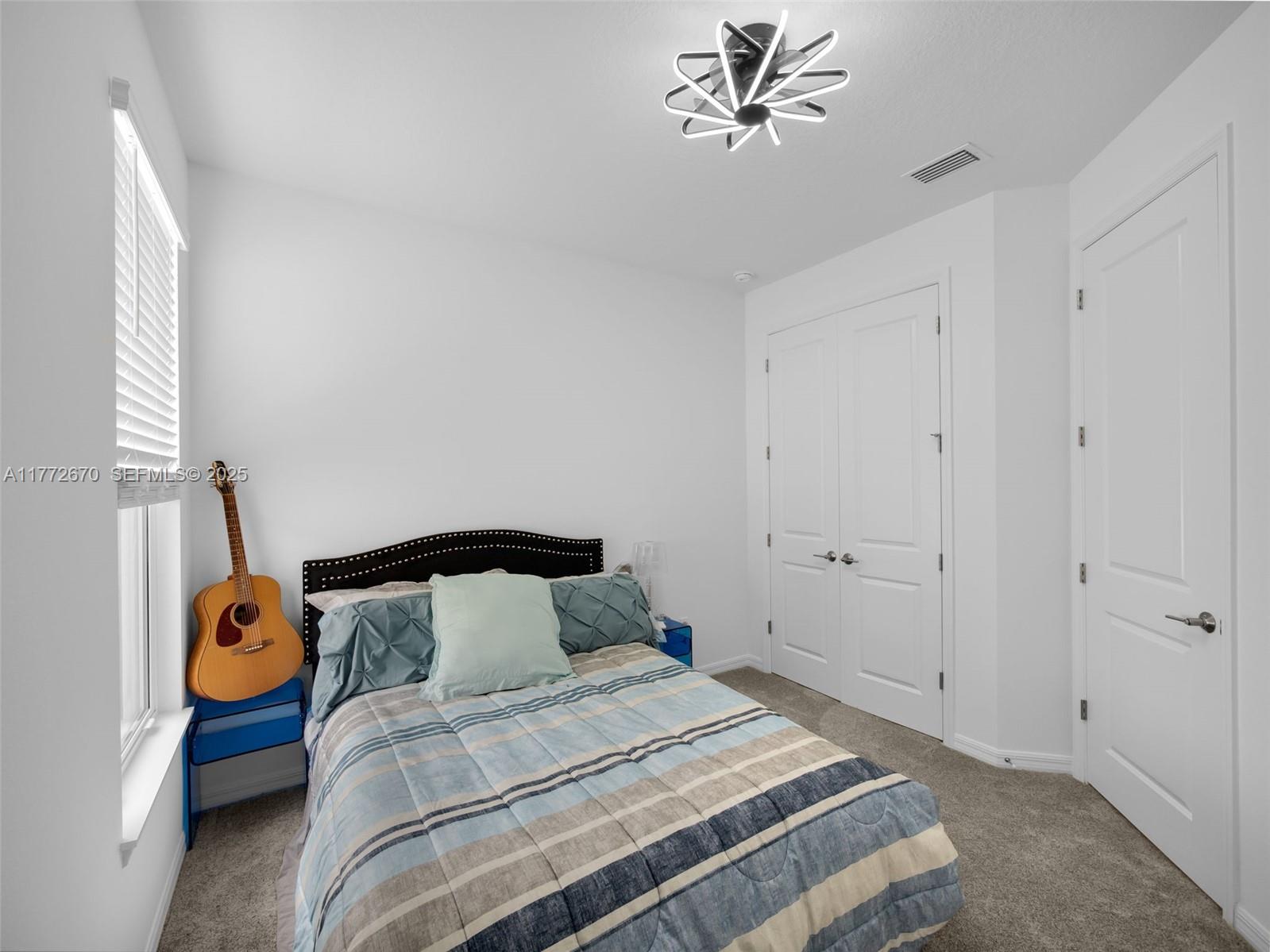 516 Ranch Oak Circle Port St. Lucie, FL 34984 - Photo 15 of 44 a bedroom with a bed and a chandelier