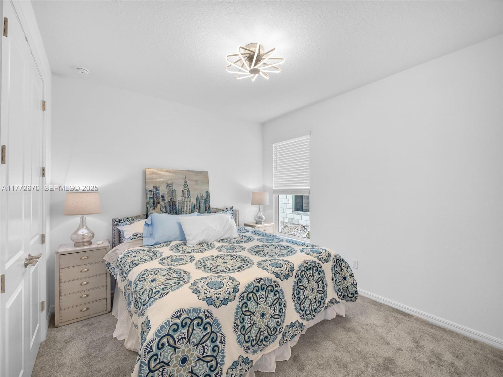 516 Ranch Oak Circle Port St. Lucie, FL 34984 - Photo 16 of 44 a bedroom with a large bed and a chandelier