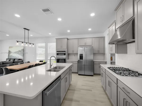 a large kitchen with a table and chairs