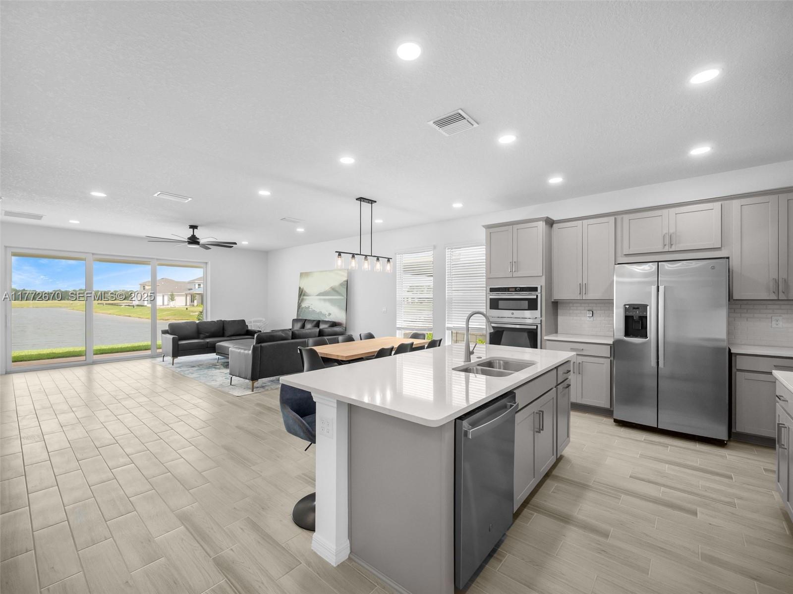 516 Ranch Oak Circle Port St. Lucie, FL 34984 - Photo 4 of 44 a large white kitchen with lots of counter space a sink appliances and a large window