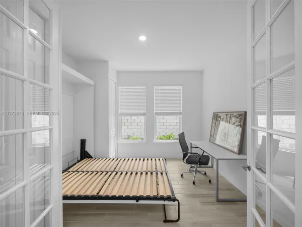 a bedroom with a bed and wooden floor