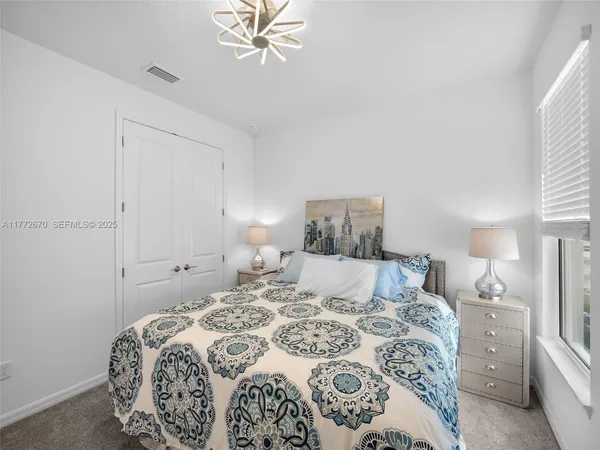 a bedroom with a bed and a chandelier