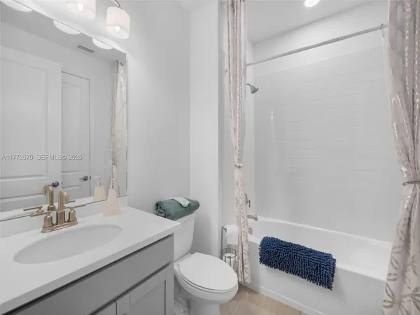 a bathroom with a sink a toilet a mirror and shower
