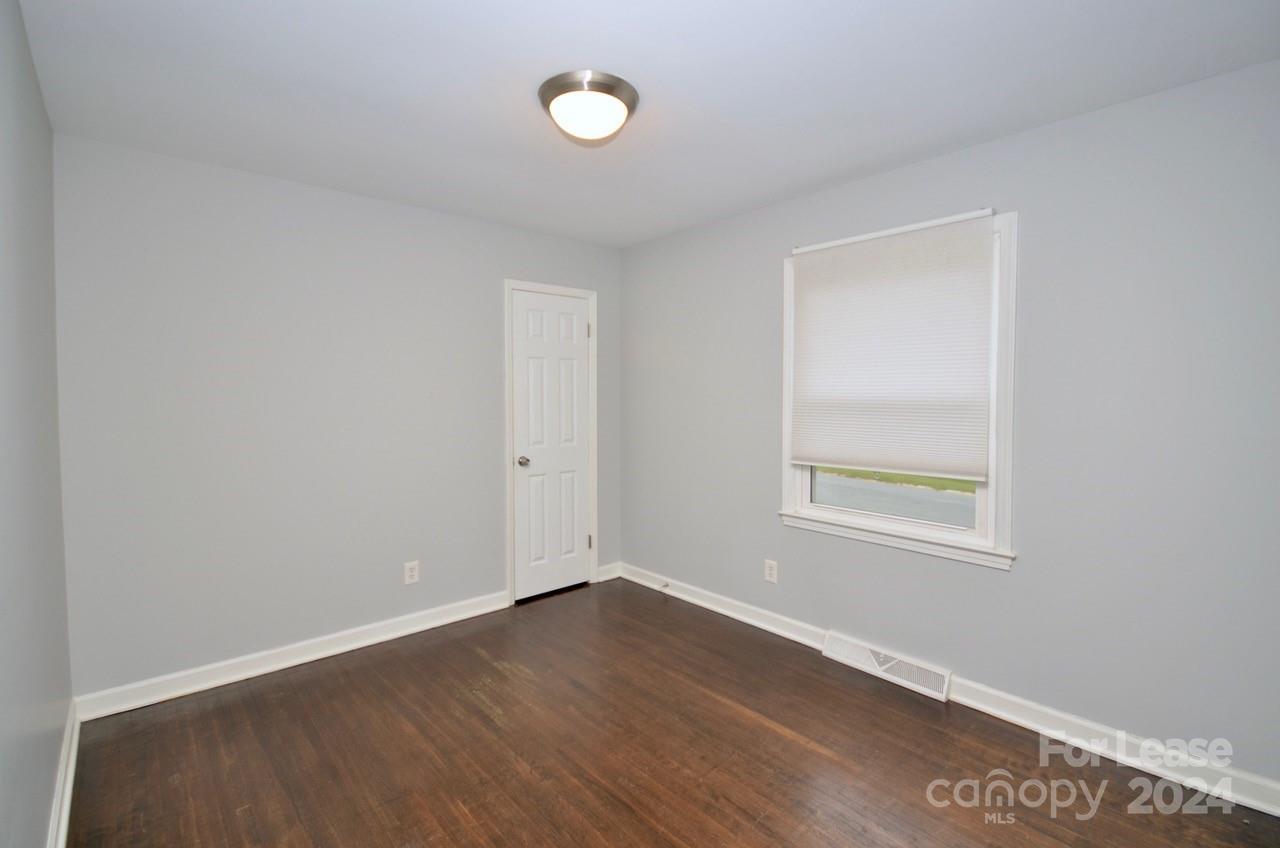 6334 Beecher Drive Charlotte, NC 28215 - Photo 12 of 27 an empty room with wooden floor and windows