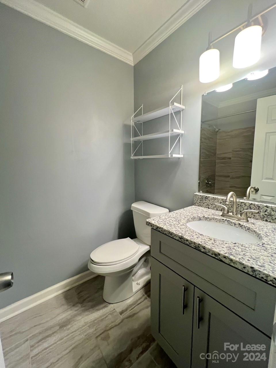 6334 Beecher Drive Charlotte, NC 28215 - Photo 13 of 27 a bathroom with a granite countertop toilet sink and mirror