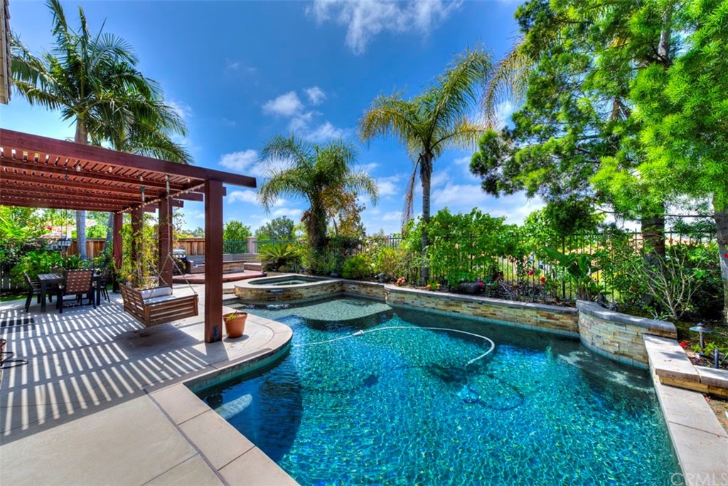 a view of swimming pool with chairs and plants