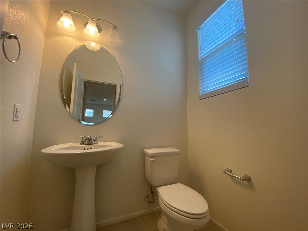 436 Cadence View Way Henderson, NV 89011 - Photo 27 of 36 A well-appointed powder room features a pedestal sink and overhead vanity lighting.