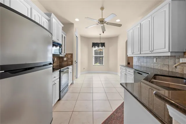 a kitchen with granite countertop a stove a sink and a refrigerator