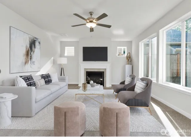 a living room with furniture a large window and a fireplace
