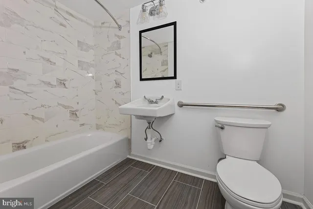 a bathroom with a toilet a sink and bathtub