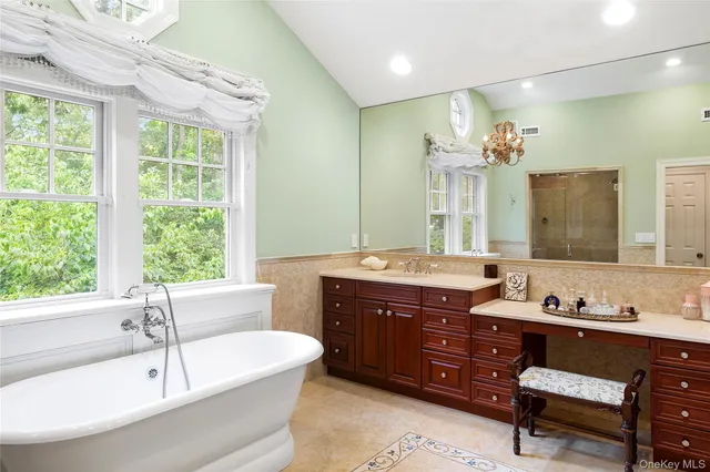 a bathroom with a tub sink and mirror