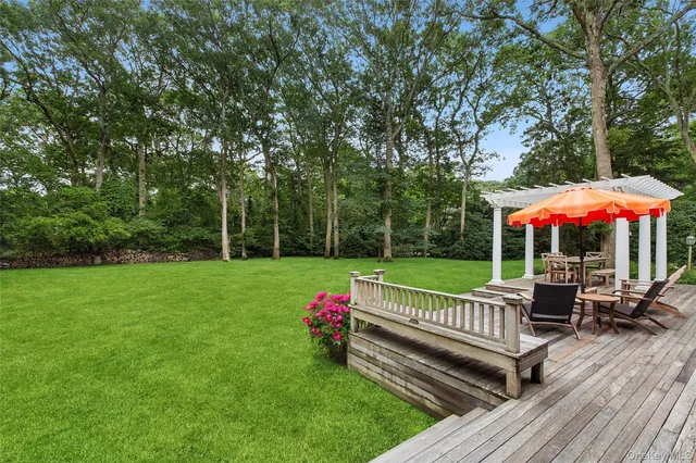 a view of a wooden deck with a bench and a yard