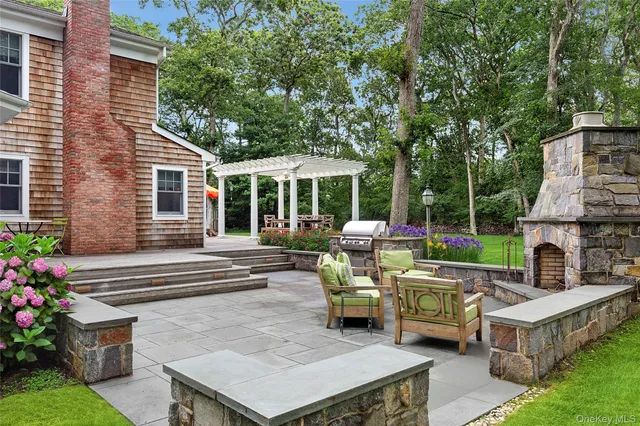 a view of a patio with couches table and chairs potted plants with large tree
