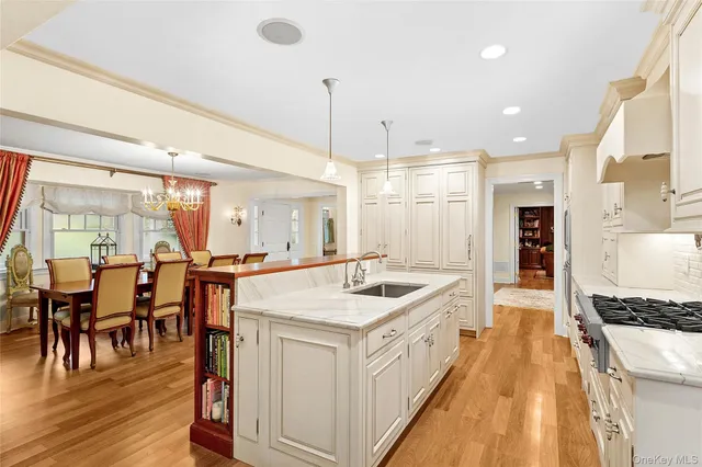 a large white kitchen with lots of counter top space and stainless steel appliances