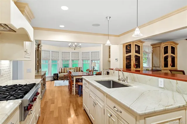 a kitchen that has a lot of cabinets a sink and wooden floor