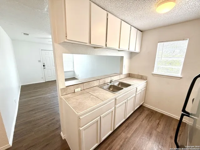 a utility room with wooden floor washer and dryer