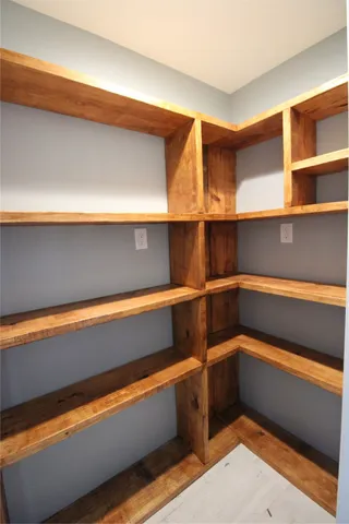 a view of walk in closet with empty racks