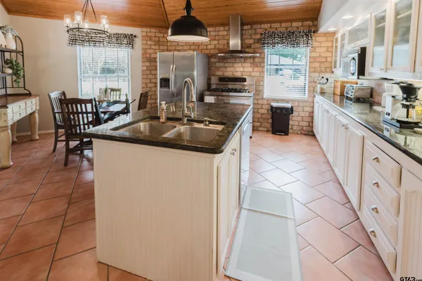 a kitchen with stainless steel appliances granite countertop a sink and a refrigerator