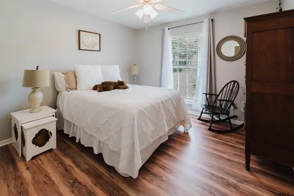 a bedroom with a bed and a table with wooden floor