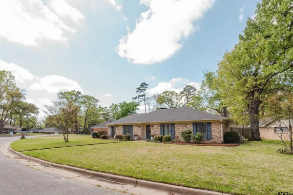 a view of a big house with a big yard and potted plants