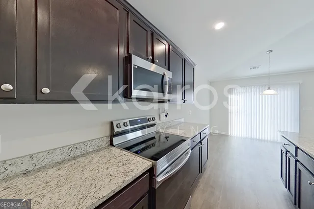 a kitchen with stainless steel appliances granite countertop a sink stove and refrigerator