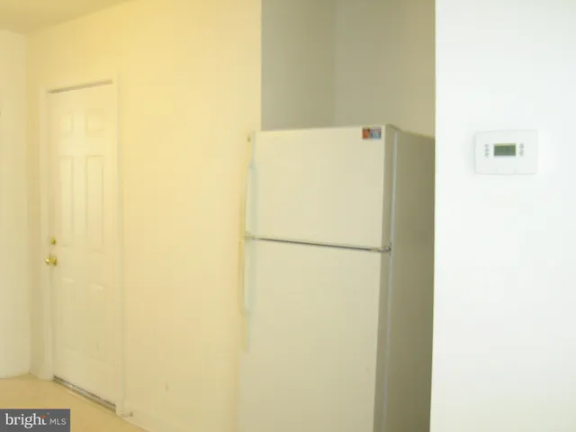 a white refrigerator freezer sitting next to a white wall