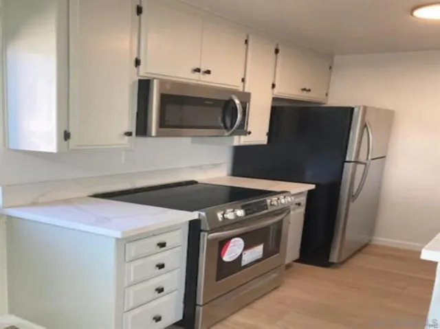 a kitchen with stainless steel appliances a stove microwave and sink