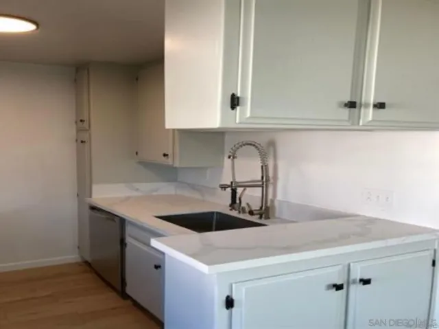 a kitchen with stainless steel appliances a stove top oven and a wooden floors
