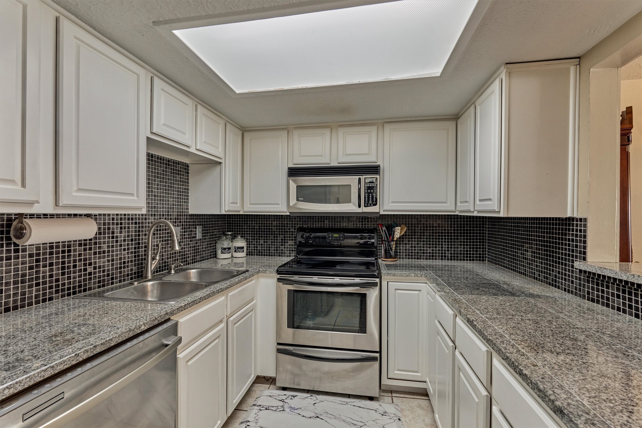 39 Regency Point Conroe, TX 77356 - Photo 22 of 44 a kitchen with granite countertop white cabinets and stainless steel appliances