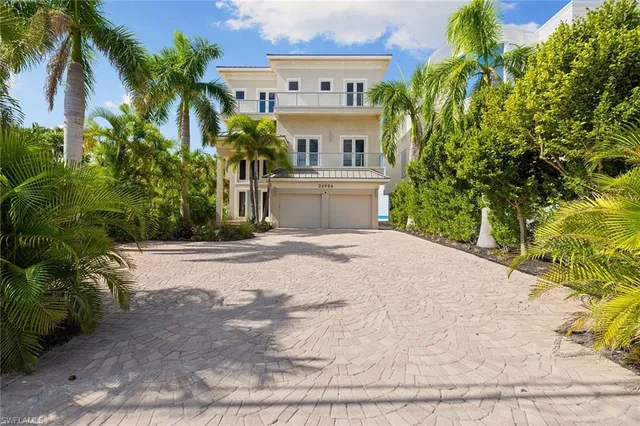 a white house that has a tree in front of it