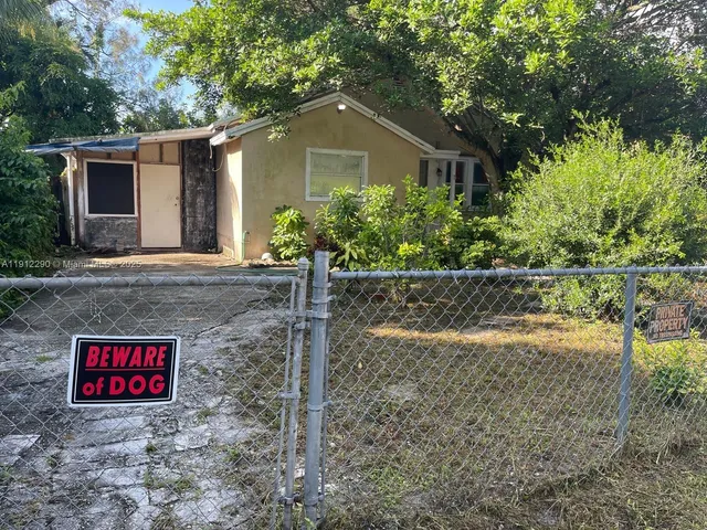 a brick house with yard and parking space