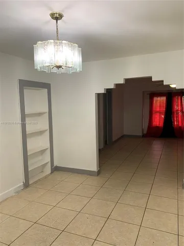 a view of a livingroom with an empty space and a window