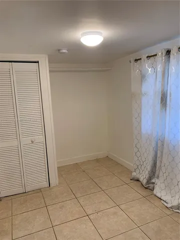 an empty room with wooden floor and brick walls