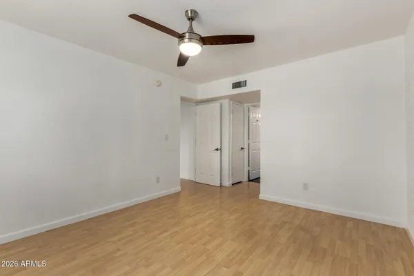 an empty room with a window and a ceiling fan
