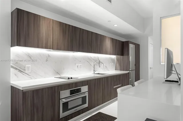 a kitchen with a sink and a stove top oven