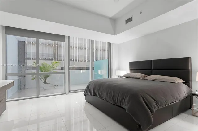 a bedroom with a bed and glass door