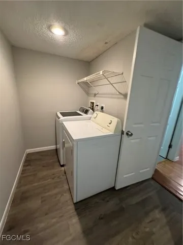 a utility room with wooden floor washer and dryer