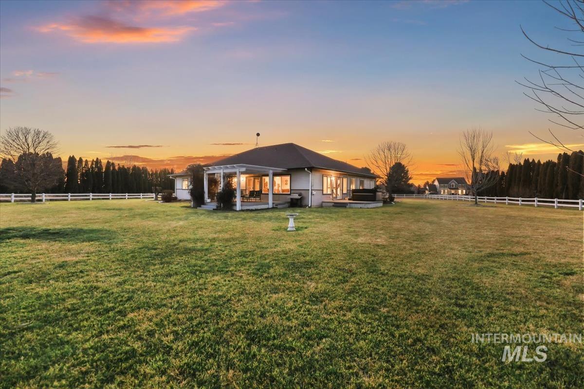 3366 North Croft Way Eagle, ID 83616 - Photo 24 of 33 Back of house at dusk with a fenced backyard and a patio area